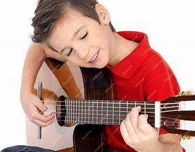 child with a smile holding
a guitar